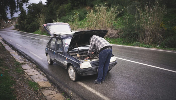 Ricardo Severin arreglando un carro viejo accidentado.