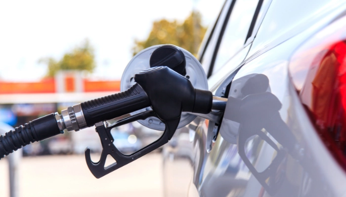 Ricardo Severin cargando gasolina en un carro en una estación de servicio