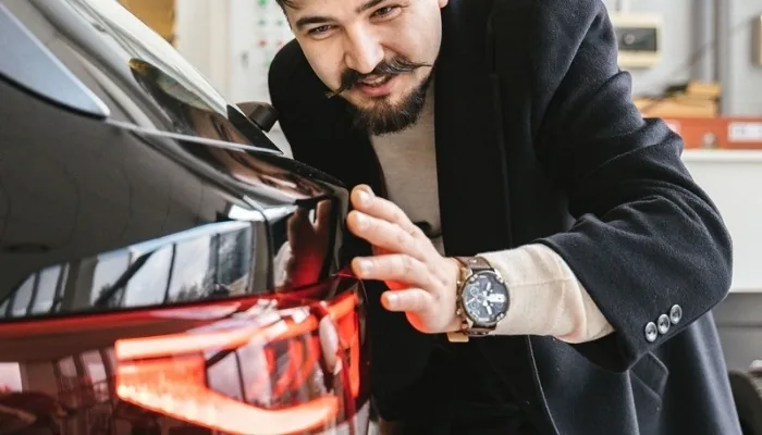 Comprador revisando la carrocería de un carro usado en Venezuela