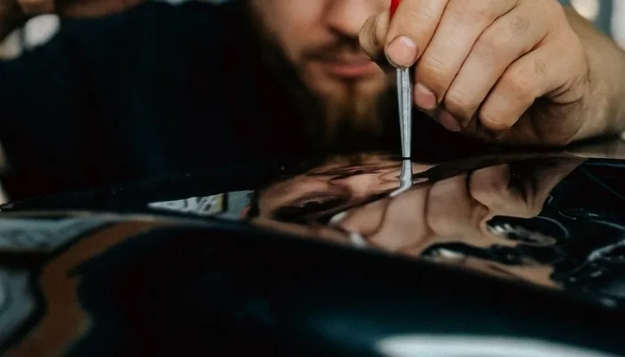 Revisión de cerca de la pintura de un carro para detectar reparaciones