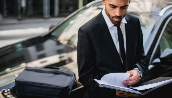 Hombre revisando la documentación de un carro usado antes de comprarlo