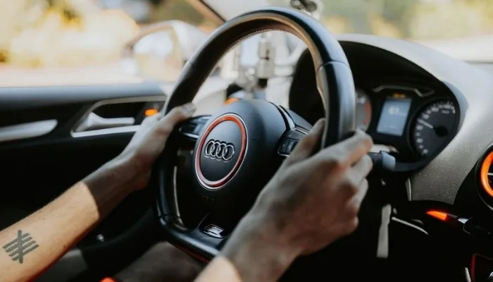 Manos en el volante durante la prueba de manejo de un carro usado